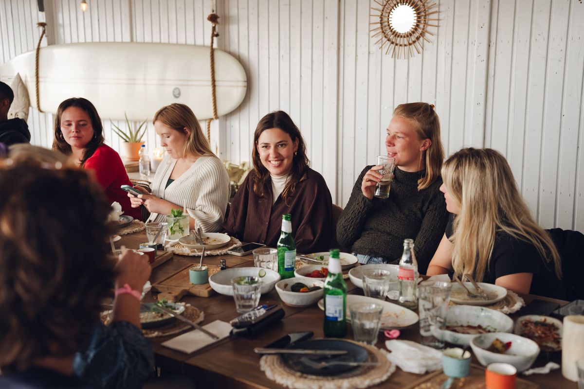 Friends enjoying a relaxed getaway together at a beach club table